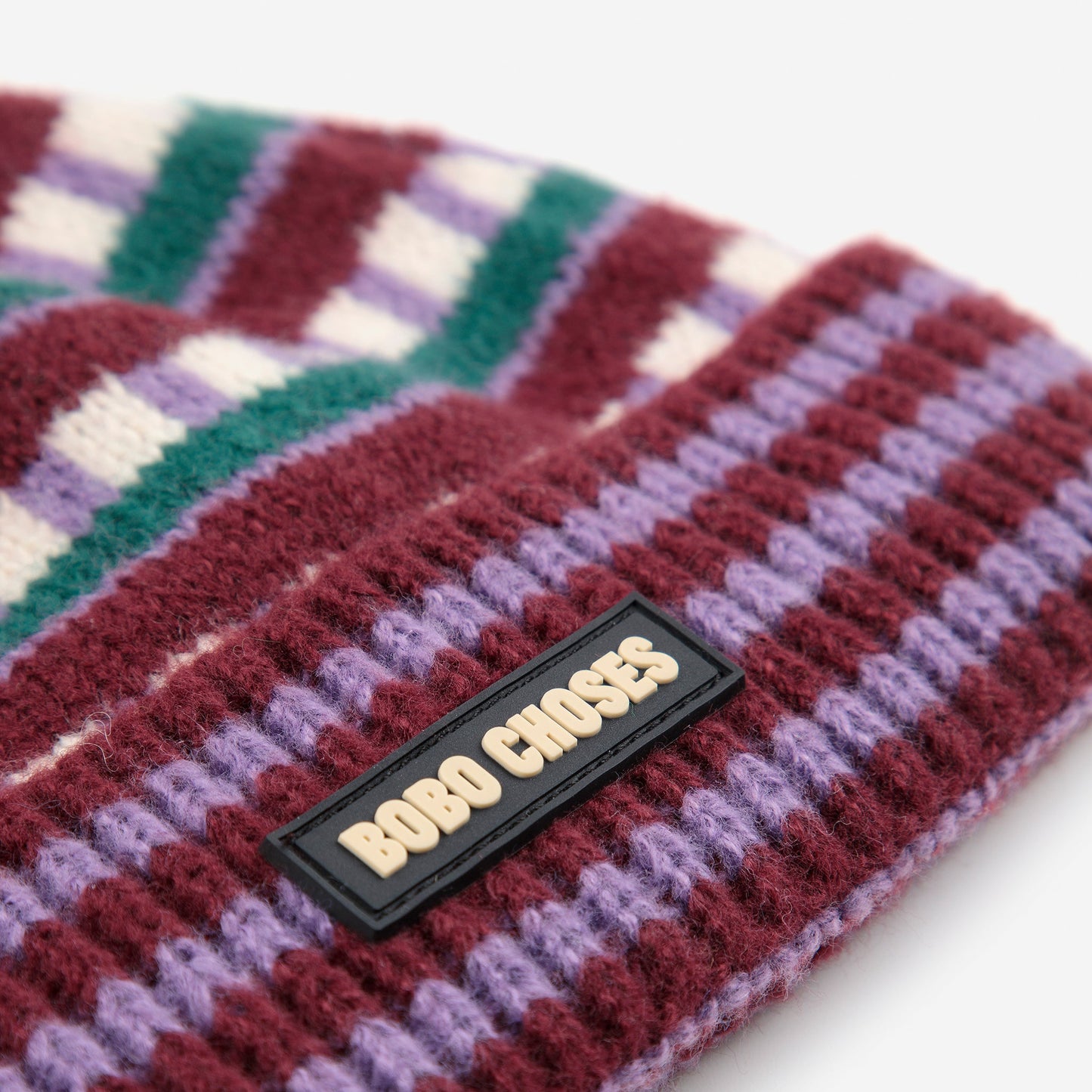 Colorful knitted headband with a brand label on a white background