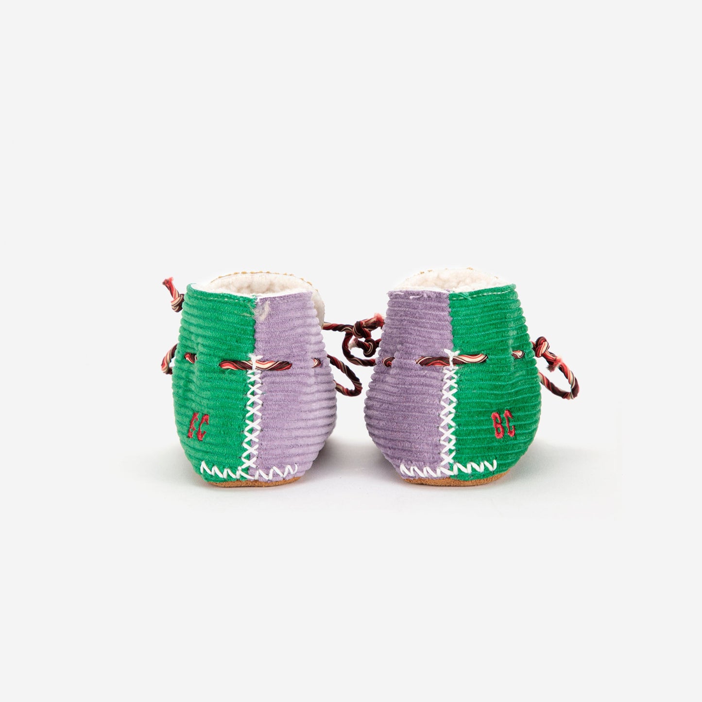 Pair of green and purple woven shoes on a white background