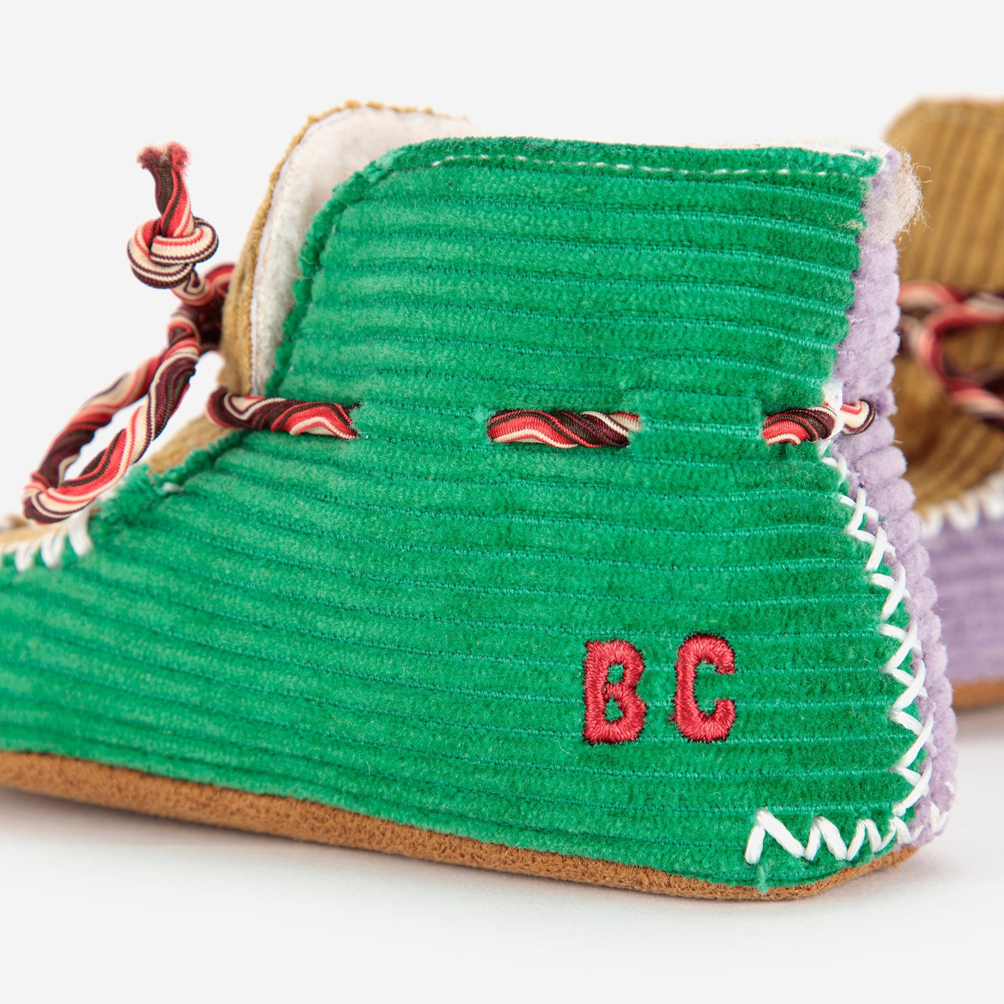 Green slippers with 'BC' initials on a white background