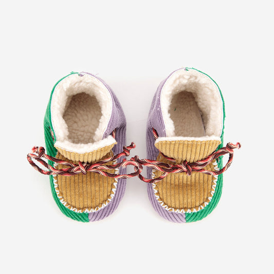 Pair of baby shoes with green and purple trim on a white background