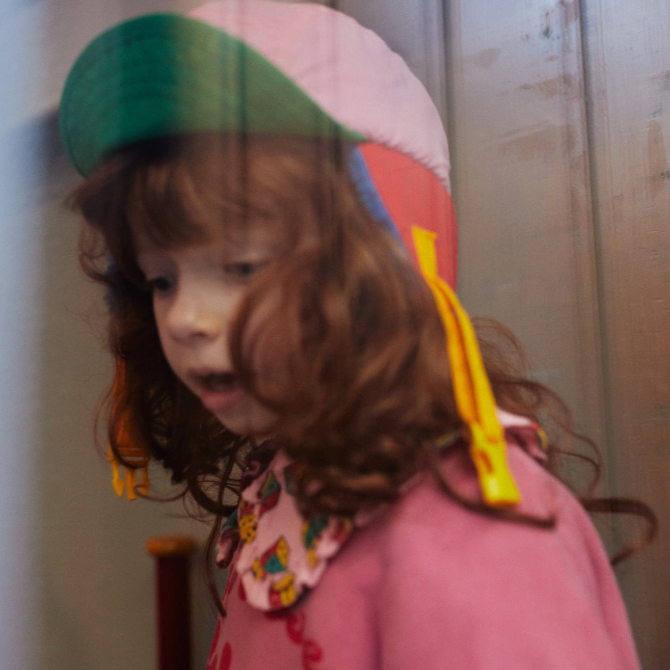 Child wearing a colorful hat with a blurred background