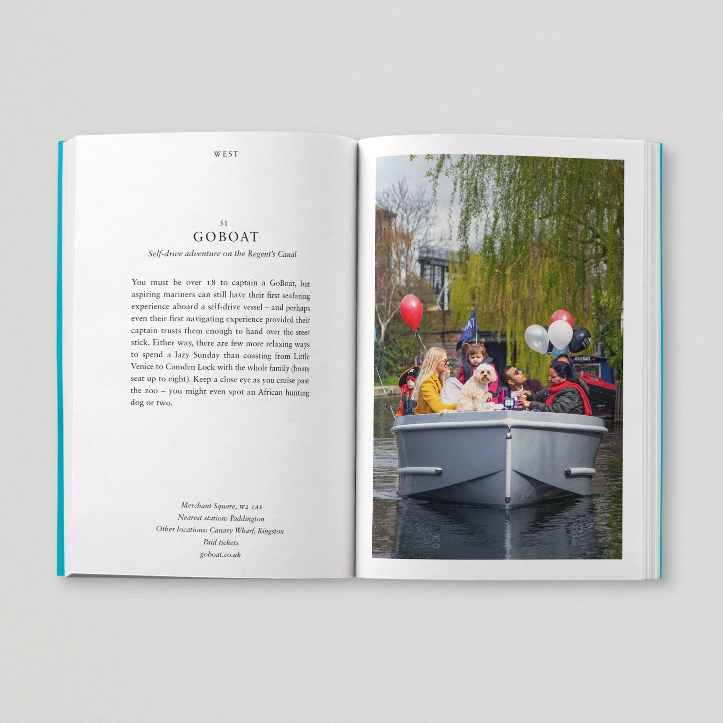 Open book with text on one page and a photograph of people on a boat on the other, against a light gray background.