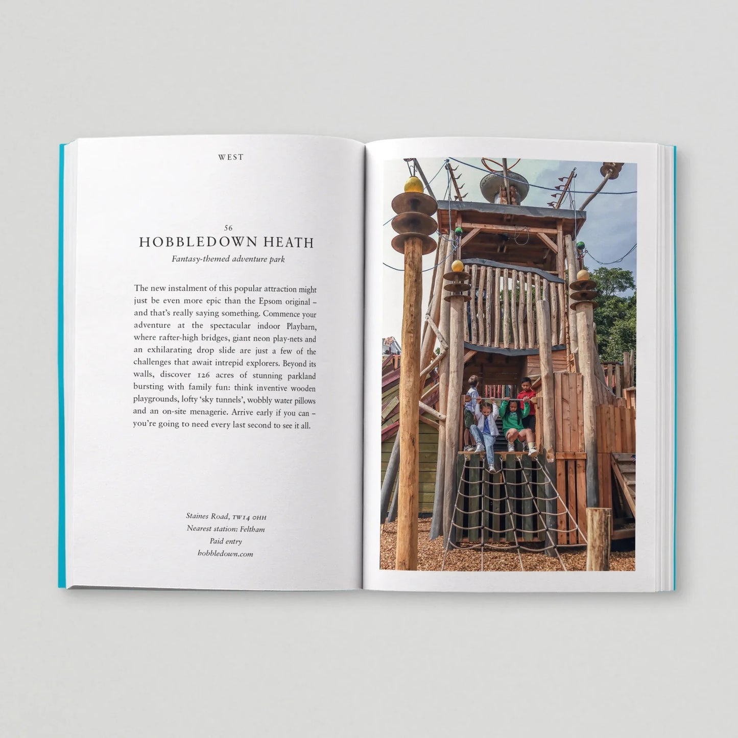 Open book showing text and a photograph of a playground structure.