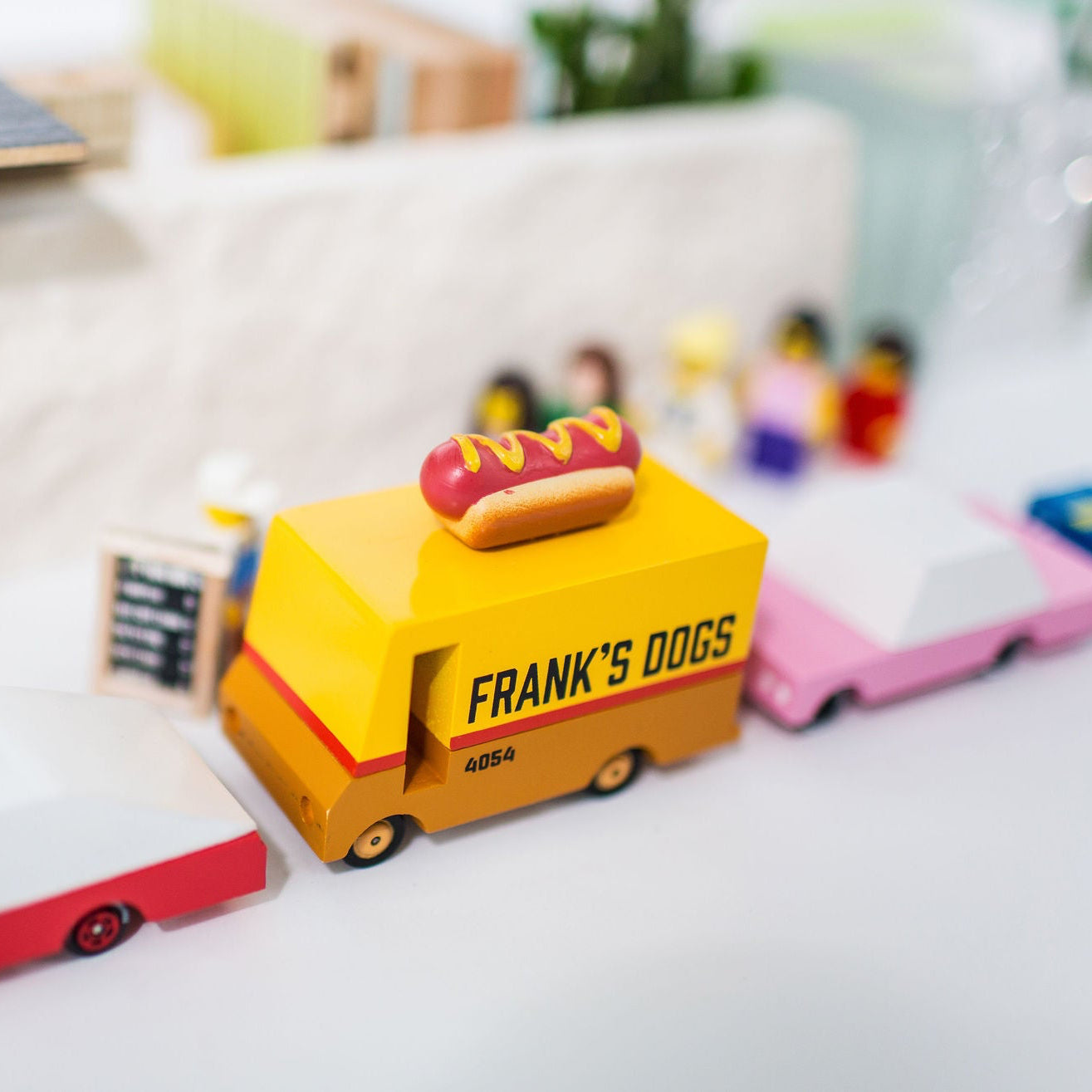 Toy hot dog cart with 'Frank's Dogs' branding on a blurred background
