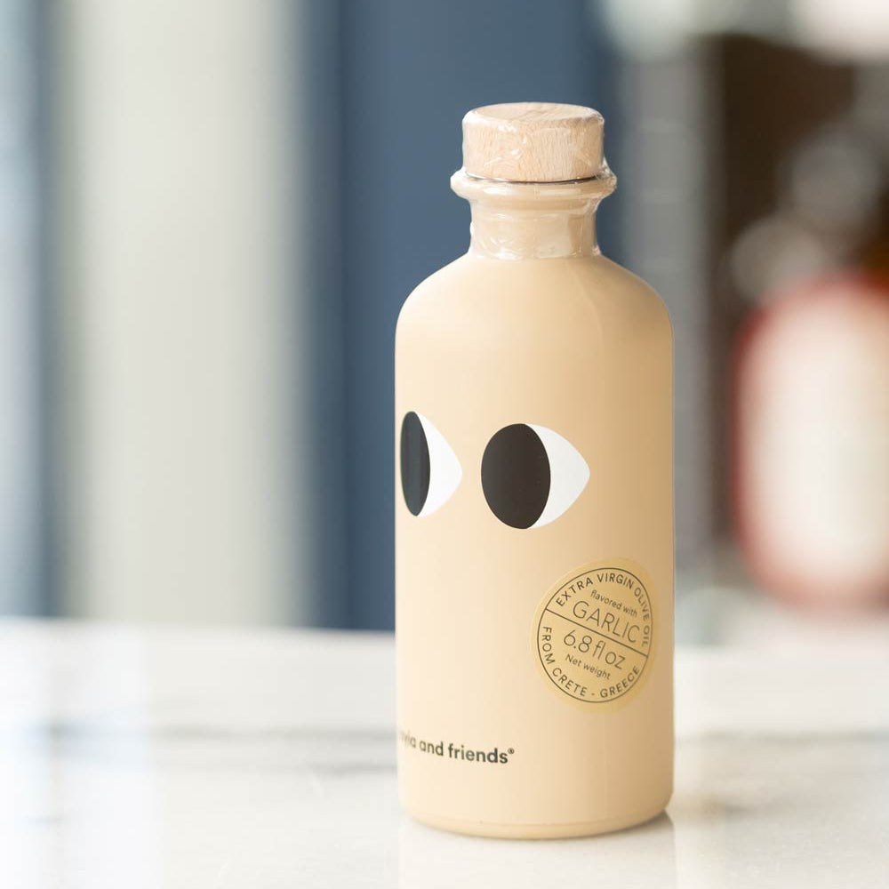 Beige bottle with black eye designs and cork cap on a blurred background