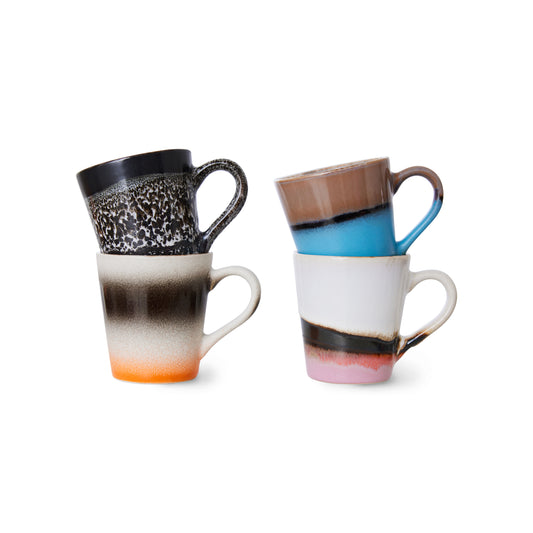 A set of 4 hkliving funky espresso mugs, displayed stacked 2 by 2 on a white backdrop. Starting with the black mug with natural white speckles and underneath is a mug with an orange bottom fading into cream, then black and cream again stripes. The next on has a pink to black striped bottom and the rest of the mug is white. Then the last mug on top has a bright blue bottom half with a black stripe and a drown top half