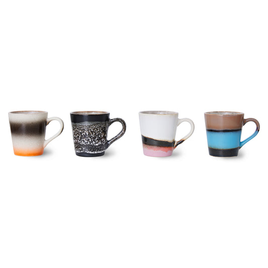 A set of 4 hkliving funky espresso mugs, displayed 1 by 1 on a white backdrop. Starting with the black mug with natural white speckles and underneath is a mug with an orange bottom fading into cream, then black and cream again stripes. The next on has a pink to black striped bottom and the rest of the mug is white. Then the last mug on top has a bright blue bottom half with a black stripe and a drown top half