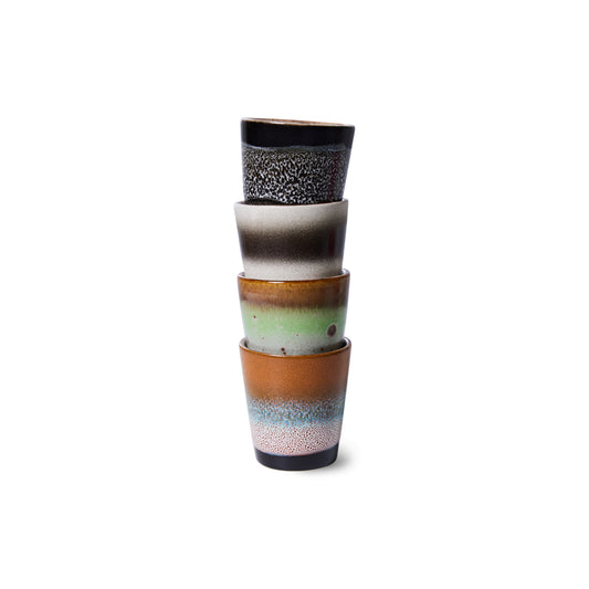 A set of four HKliving good vibes ristretto mugs, stack in a row. Colours fading from speckled cream to blue, then orange. The next has a lime green to brown, next to one with cream and dark brown stripes. And the last is black with speckled white spots fading out at the top