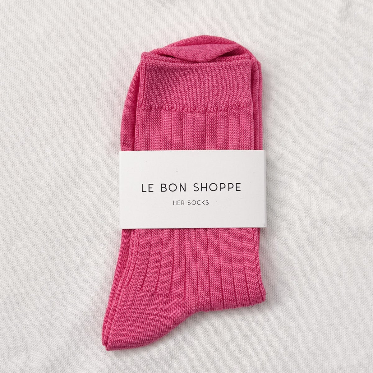 Pink socks with a white label on a light gray background