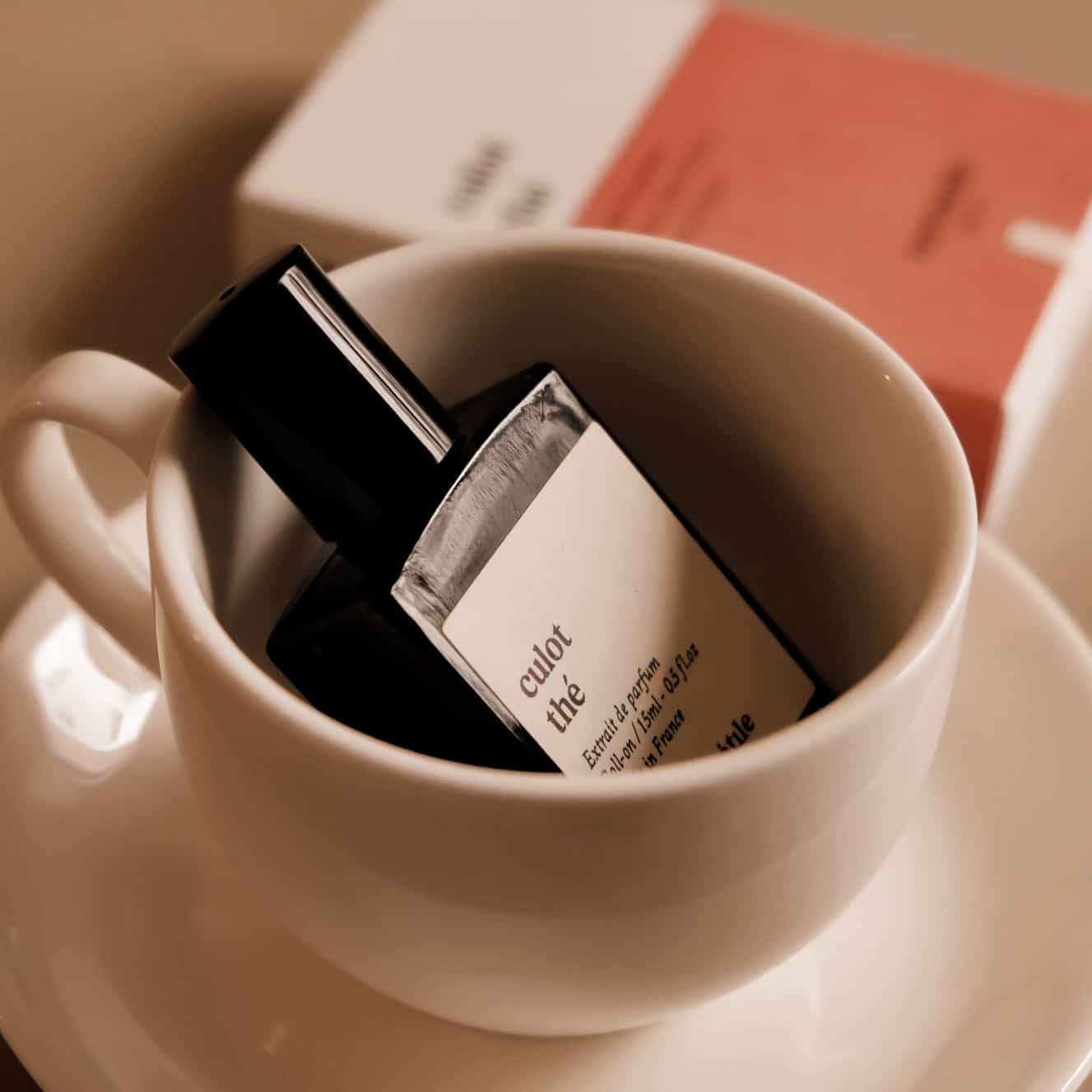 Small bottle labeled 'culot the' in a white cup with a blurred background