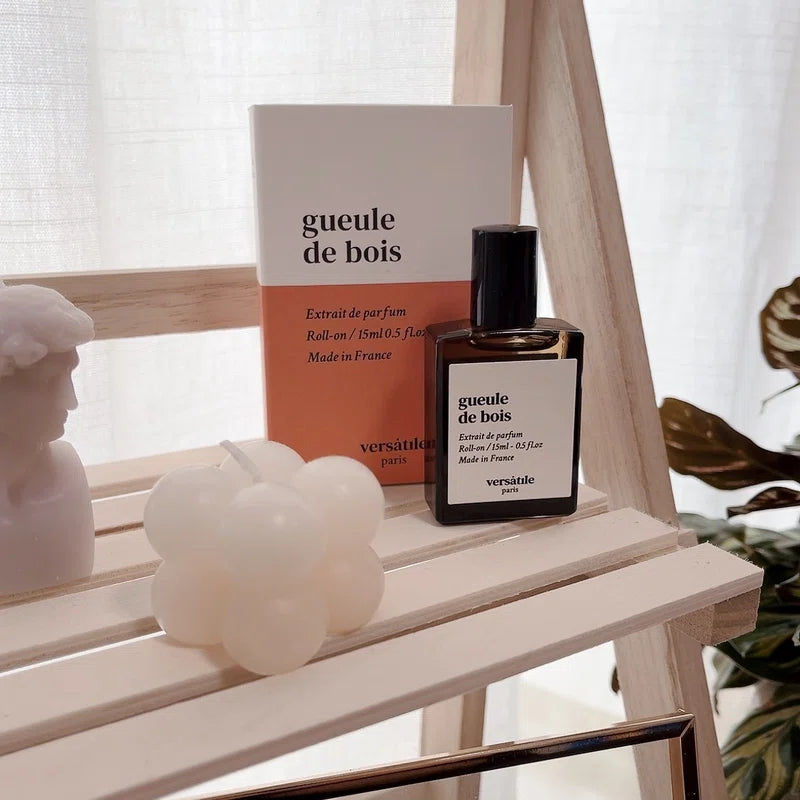 Versace 'géoule de bois' perfume bottle and packaging on a wooden surface with decorative items.