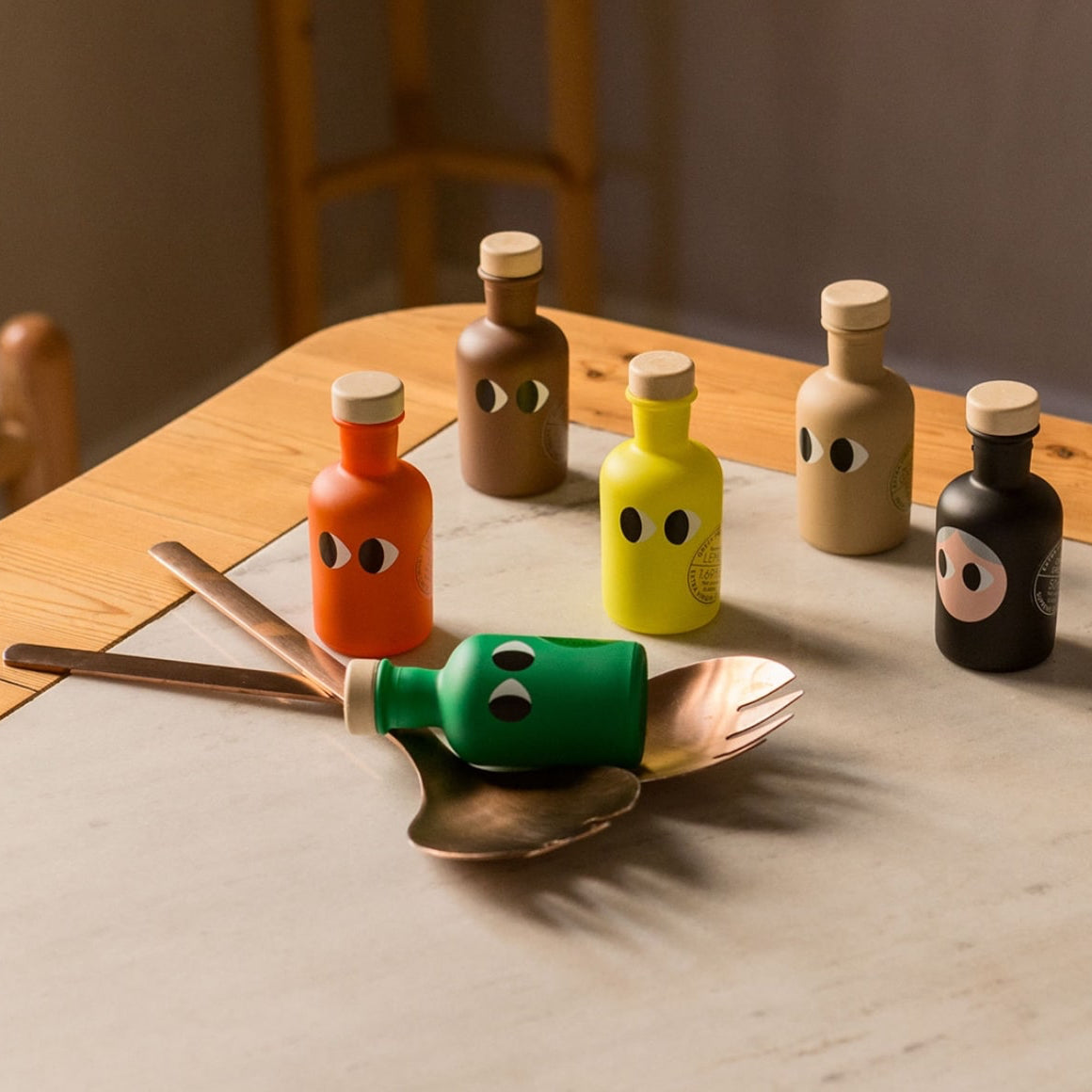 Colorful bottle stoppers with face designs on a wooden table.