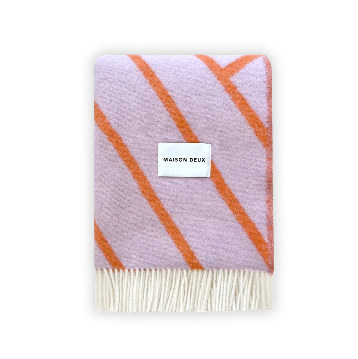 A folded Maison Deux blanket with lilac and orange lines and fringes on the short sides, displaying the brand name on a white label.