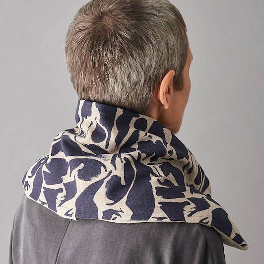 Person wearing a navy and beige patterned wheat bag on a plain background