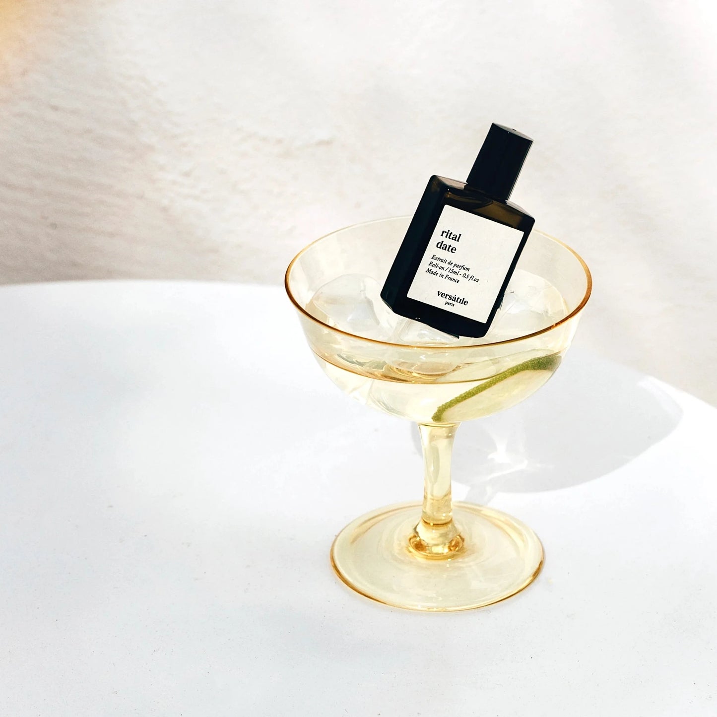 Perfume bottle on a gold stand with a white background