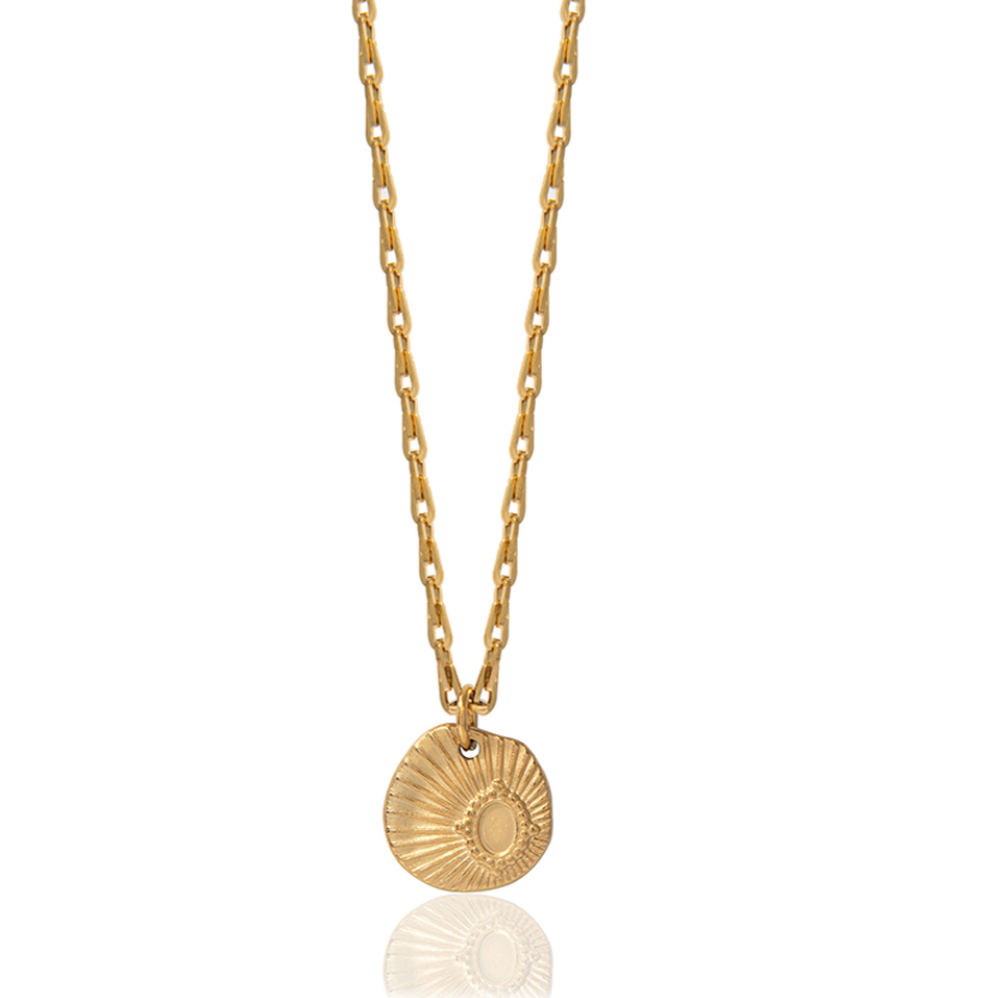 A gold-colored necklace with a simple chain design and a round gold-colored pendant that resembles a seashell.
