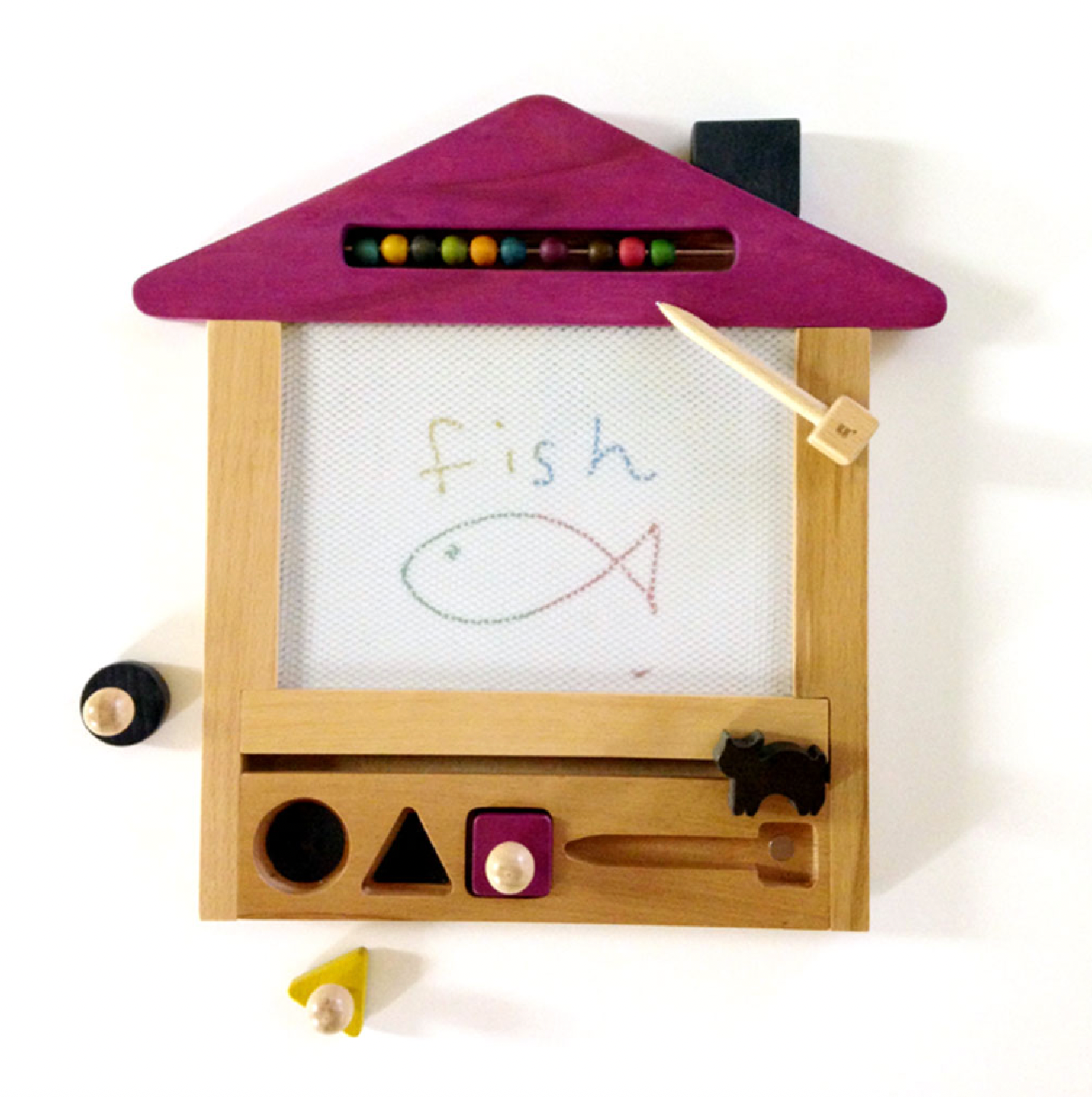 Wooden toy with purple roof, white board, and various shapes on a white background