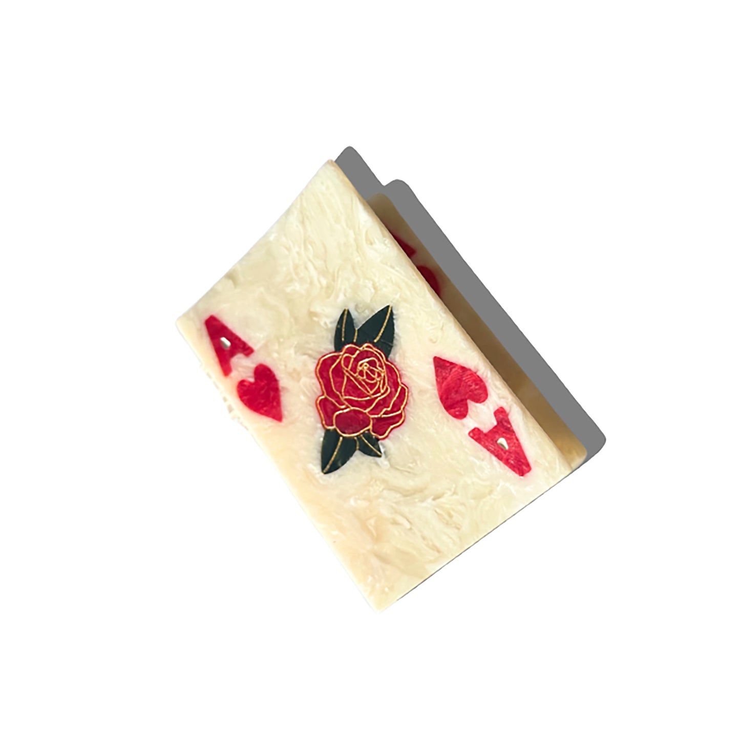 An Ace of Hearts playing card-shaped hair claw with a marbled ivory texture, red heart symbols, and a central rose motif. The delicate gold detailing enhances the design, while the clip casts a subtle shadow against a white background.