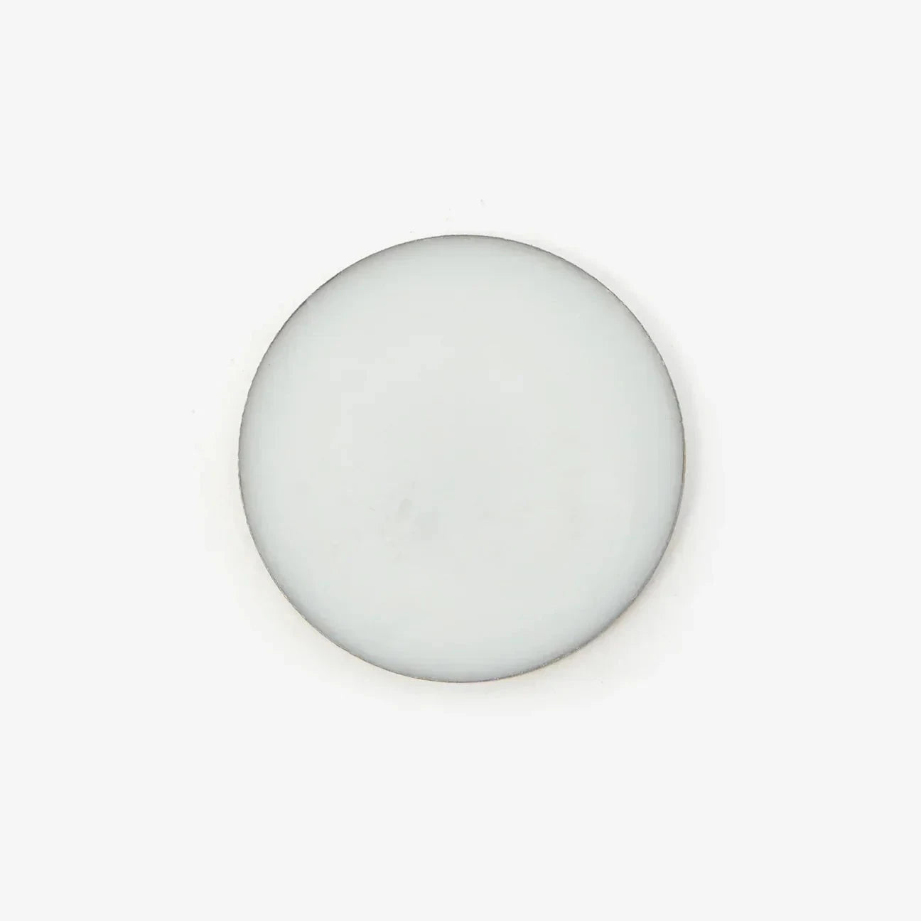 An overhead shot of a circular pot of solid perfume balm against a white background.