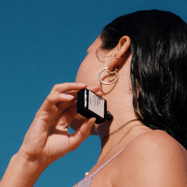 Woman applying sunscreen with a blue background