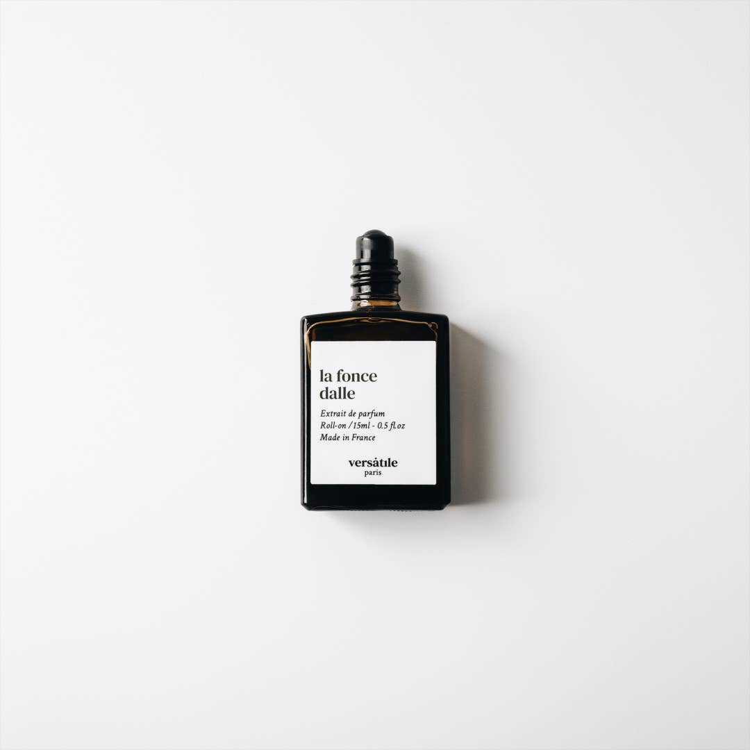 The bottle of Versatile Paris - La Foncedale Perume Roll On Genderless Fragrance with the lid off to show the roll on applicator