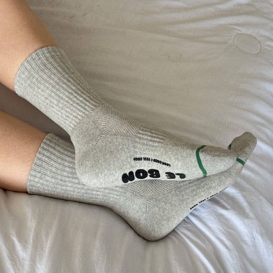 Gray socks with text on a white bed sheet