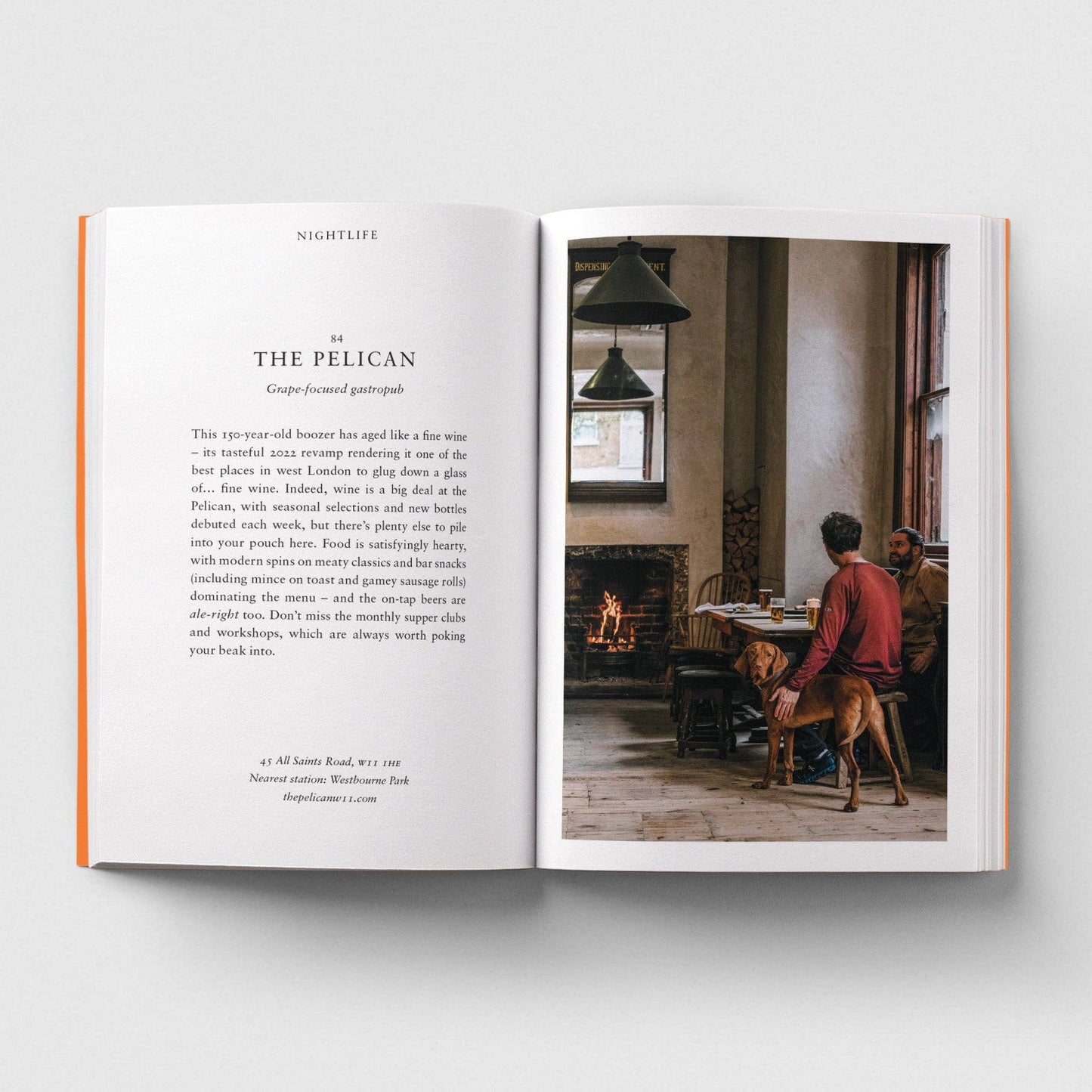 Open book showing a page with text and a photograph of a person with a dog in a room.