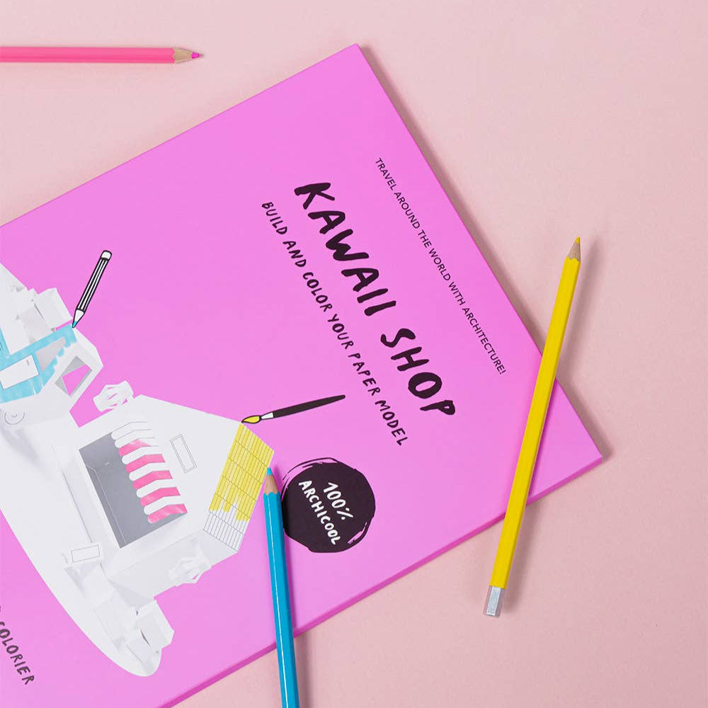 Pink notebook with robot design and colorful pencils on a pink background