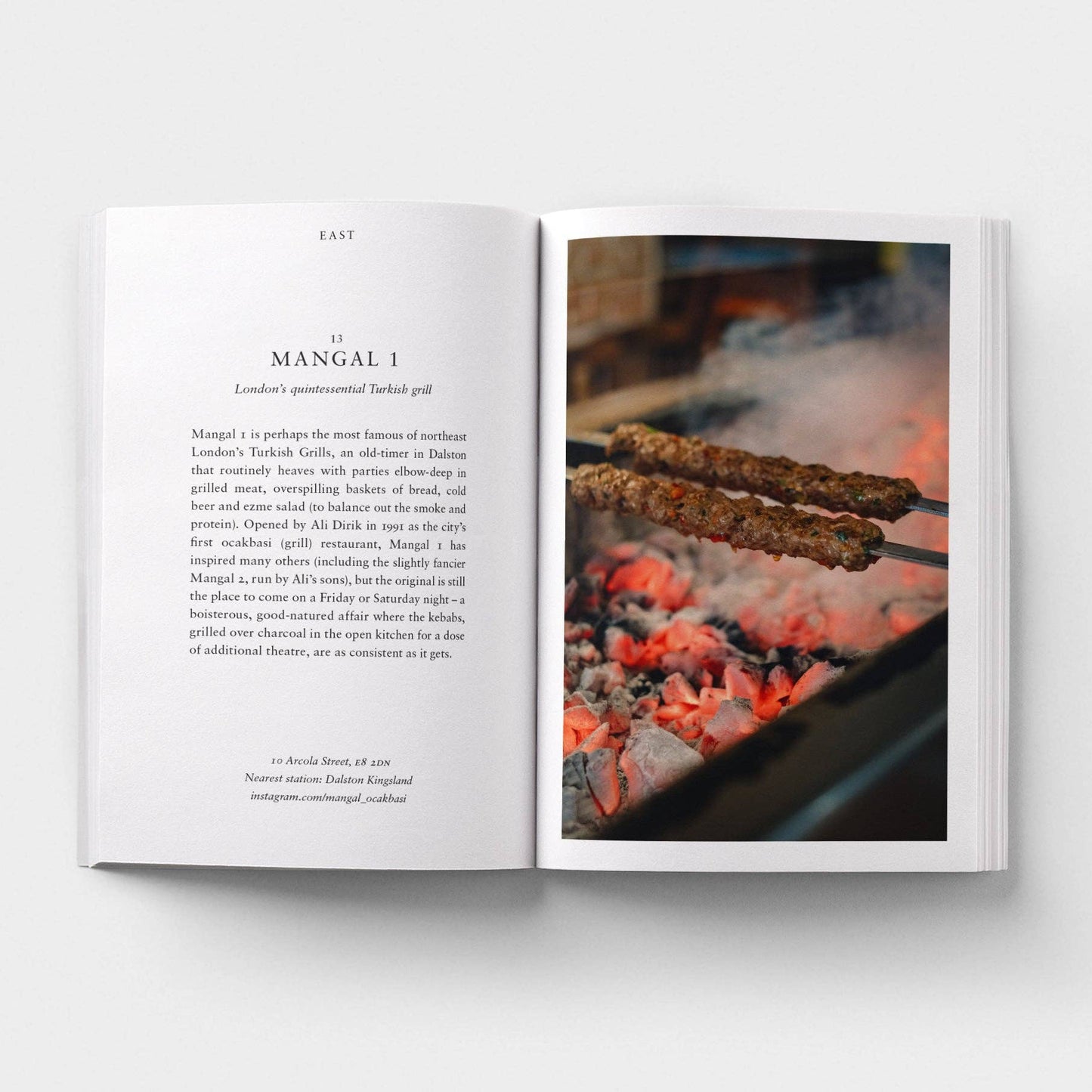 Open book showing a page with text and an image of skewers over flames.