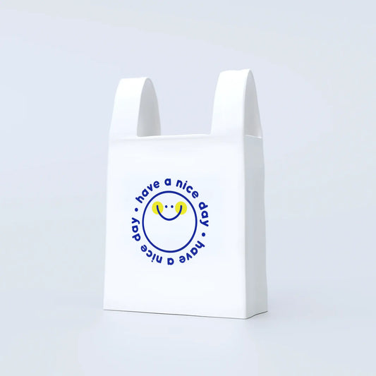 A white ceramic vase designed to resemble a plastic bag with a blue circular logo and text saying 'have a nice day' on the front.