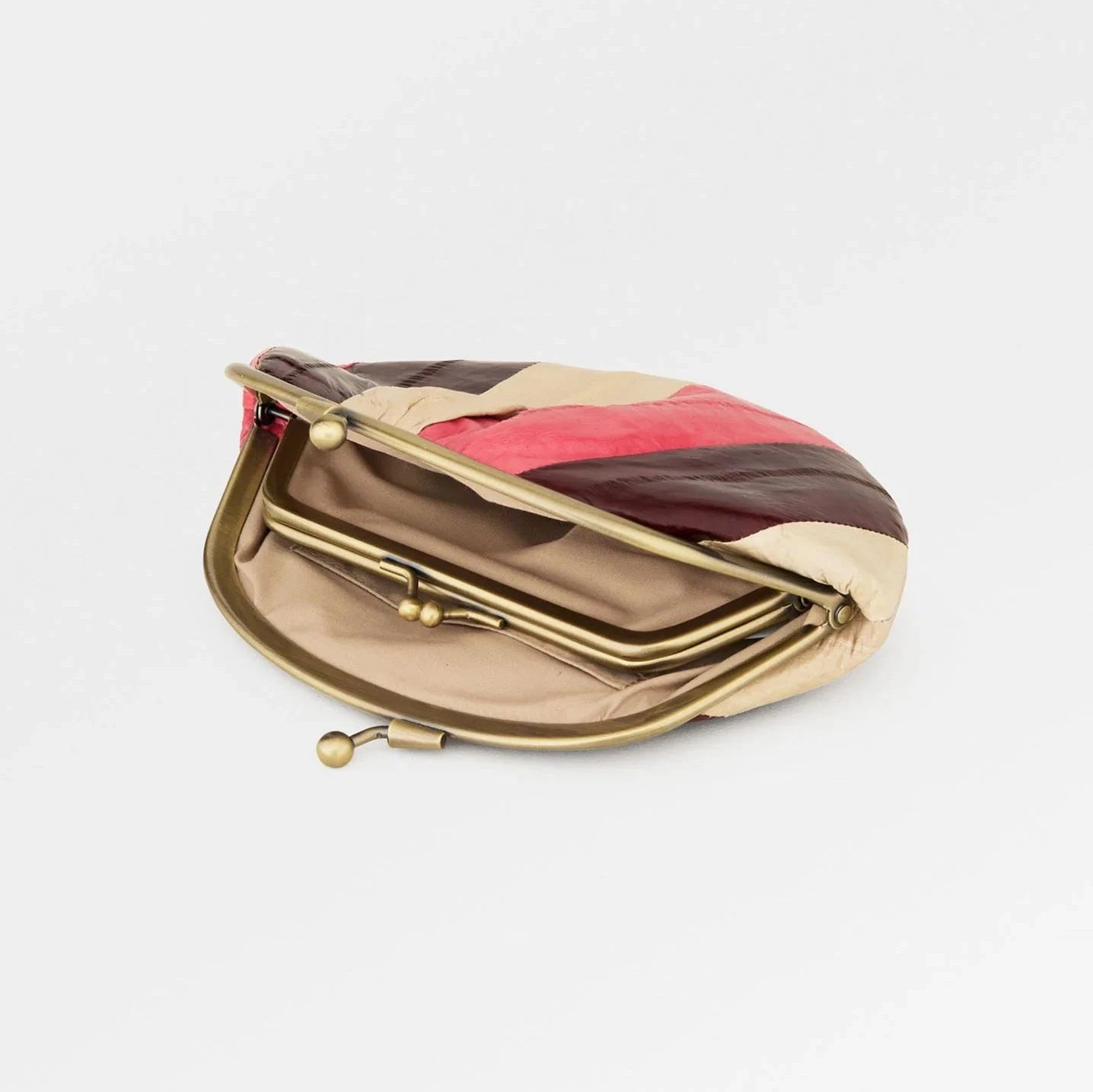 Open view of a color-blocked 'granny' style clutch purse with a gold clasp on a white background