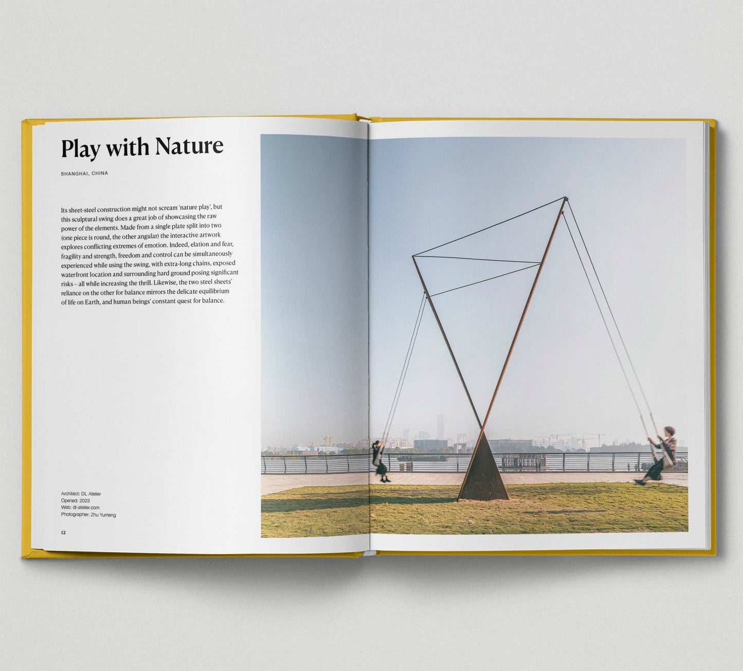 Open book showing a page with text and an image of a geometric sculpture on a grassy area.