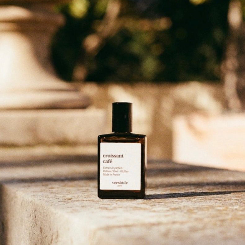 Perfume bottle labeled 'Exscentric Molecules' on a stone surface with blurred background