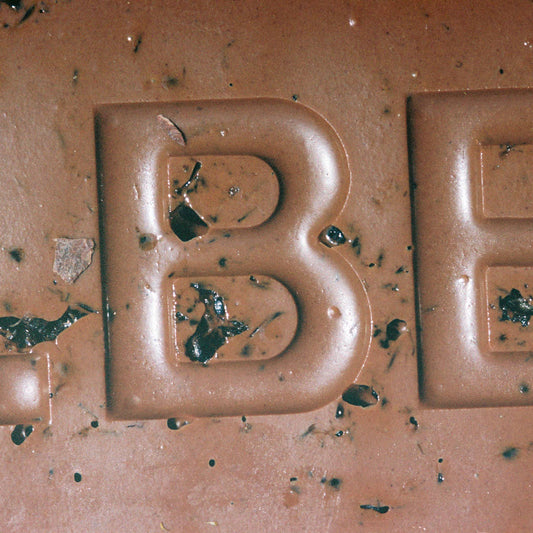 Close-up of a chocolate bar with the letter 'B' embossed on it.