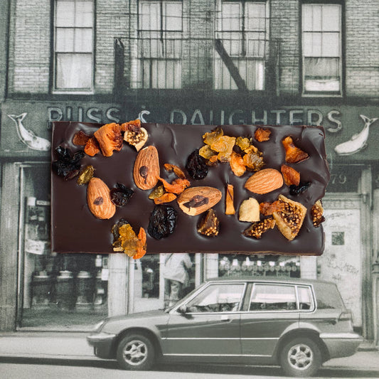 Chocolate bar with nuts and dried fruits in front of a vintage store facade