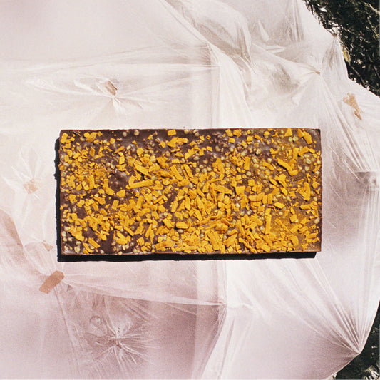 Chocolate bar with yellow crumb topping on a white background