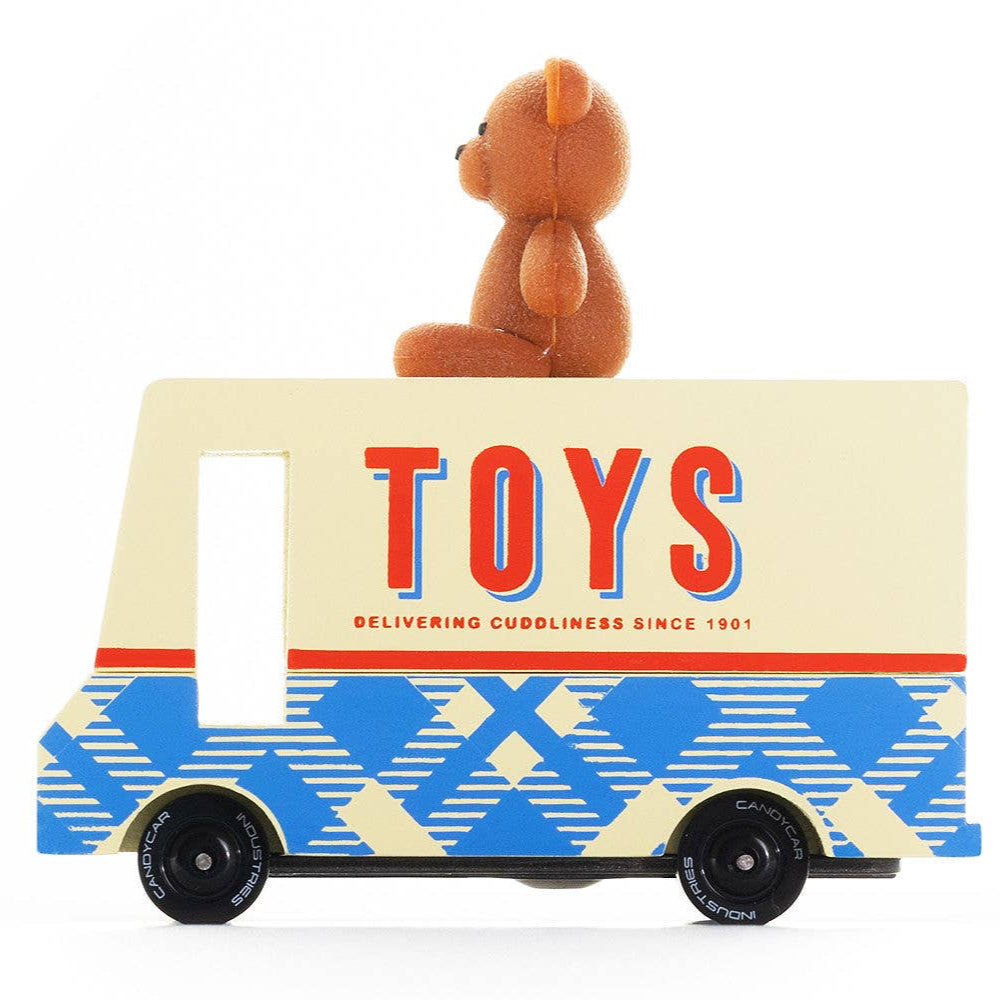A Candylab Teddy Toy Van with a teddy bear topper, featuring a colorful design with blue and geometric patterns, delivering toys with a 'TOYS' text on the side.