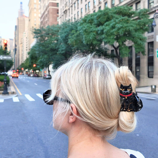 Person with blonde hair styled in a bun on a city street