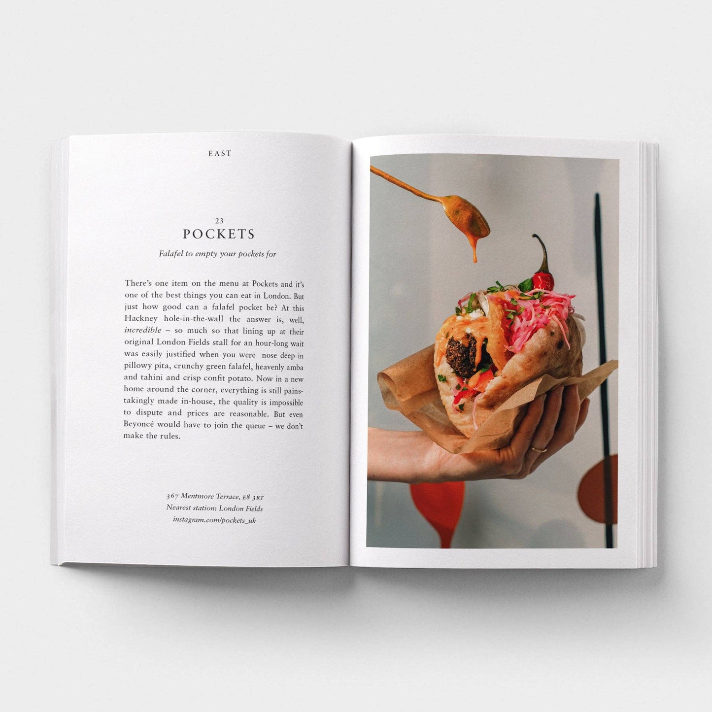 Open book showing a page with text and an image of a hand holding food.