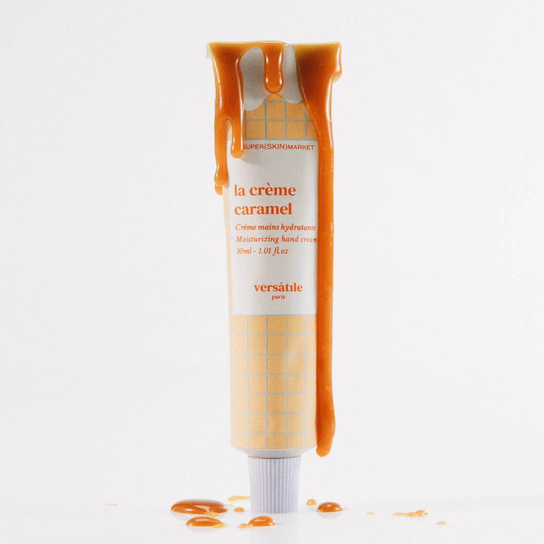 A tube of VERSATILE PARIS caramel cream hand cream with a dispenser, showing the cream dripping down the tube.