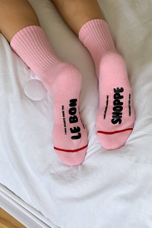 Pink socks with text on a white surface