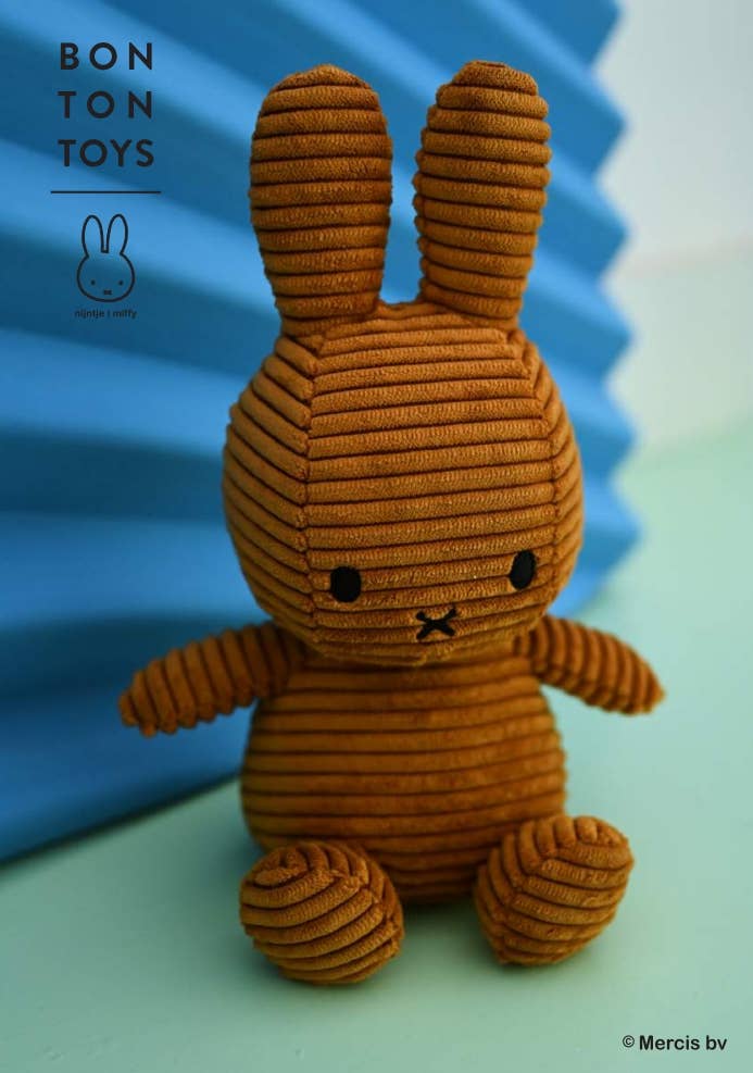 Brown corduroy toy rabbit with a blue and green gradient background, featuring the Bon Ton Toys logo.