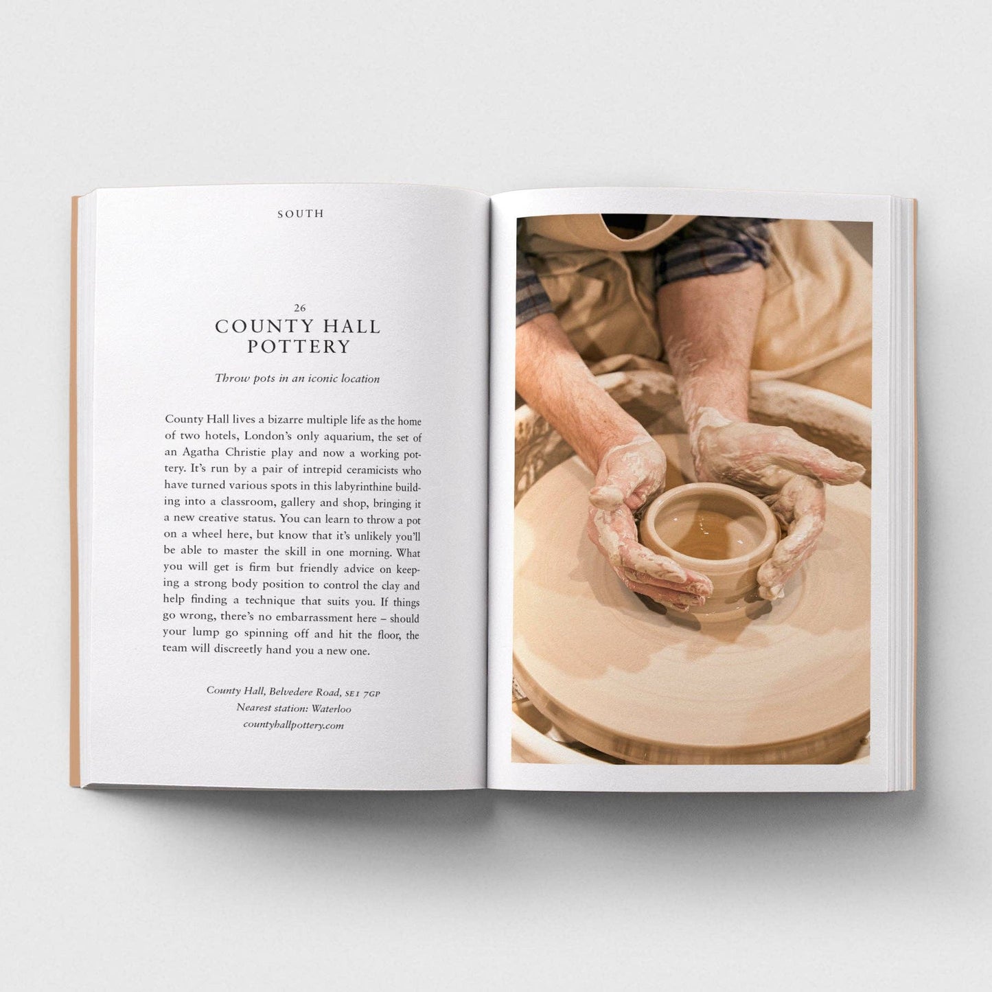 Open book showing a page with text and an image of hands working with clay on a potter's wheel.