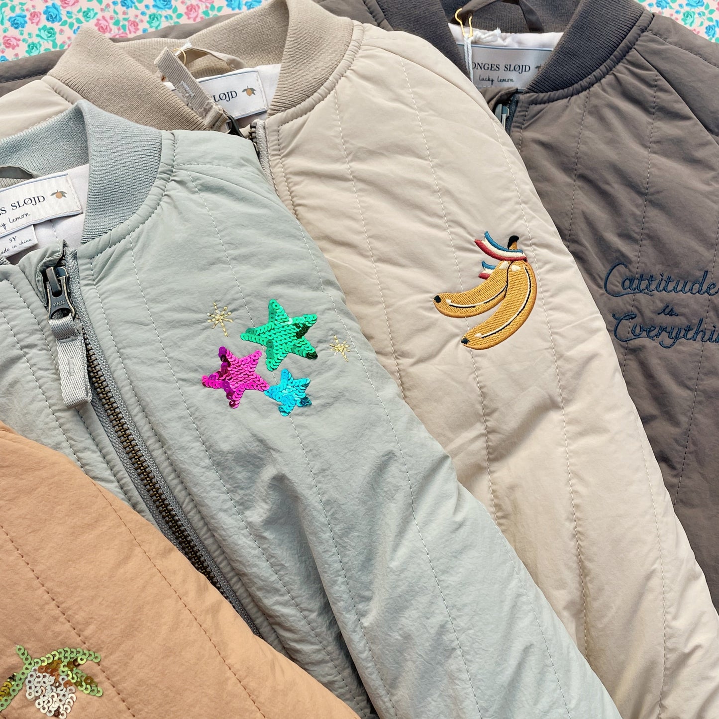 Collection of jackets with embroidered designs on a colorful background