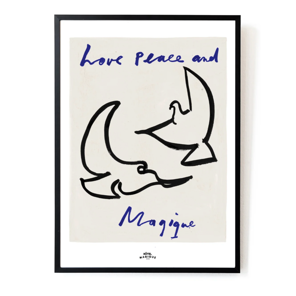 A Hotel Magique Love, Peace and Magique A3 print. The background is beige. The birds are painted in black. “Love Peace and Magique” is written in dark blue. The print is framed with a black border.