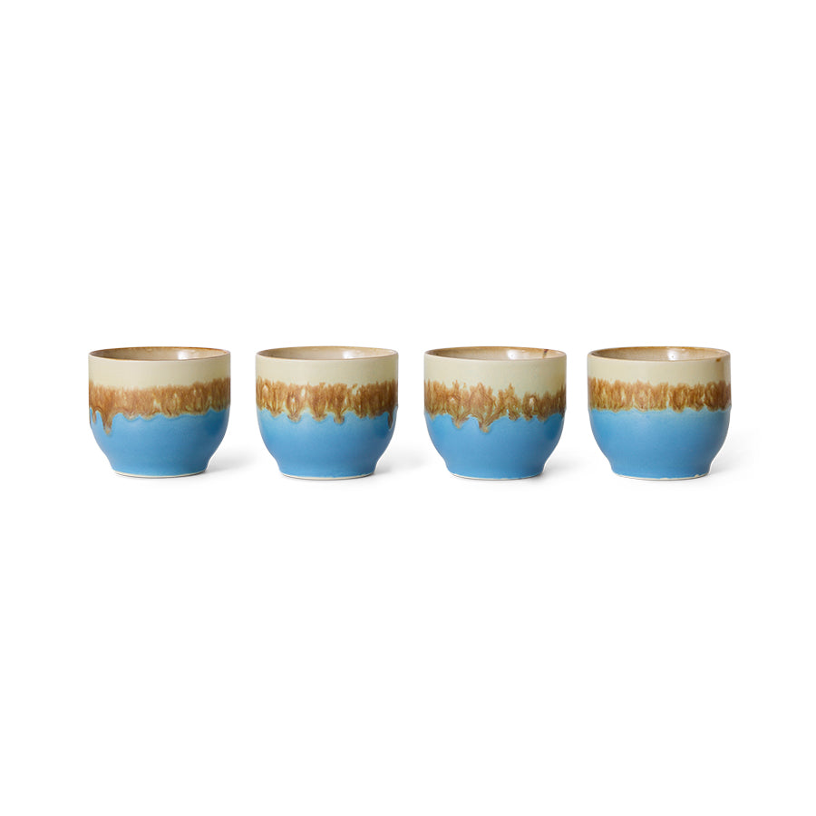 Set of four ceramic cups with blue and beige gradient design on a white background