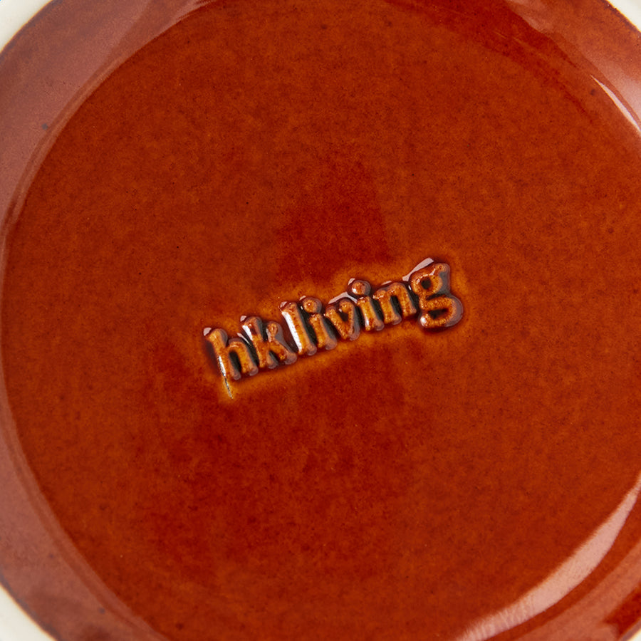 Close-up of a red ceramic dish with 'Bel活着' embossed on it.