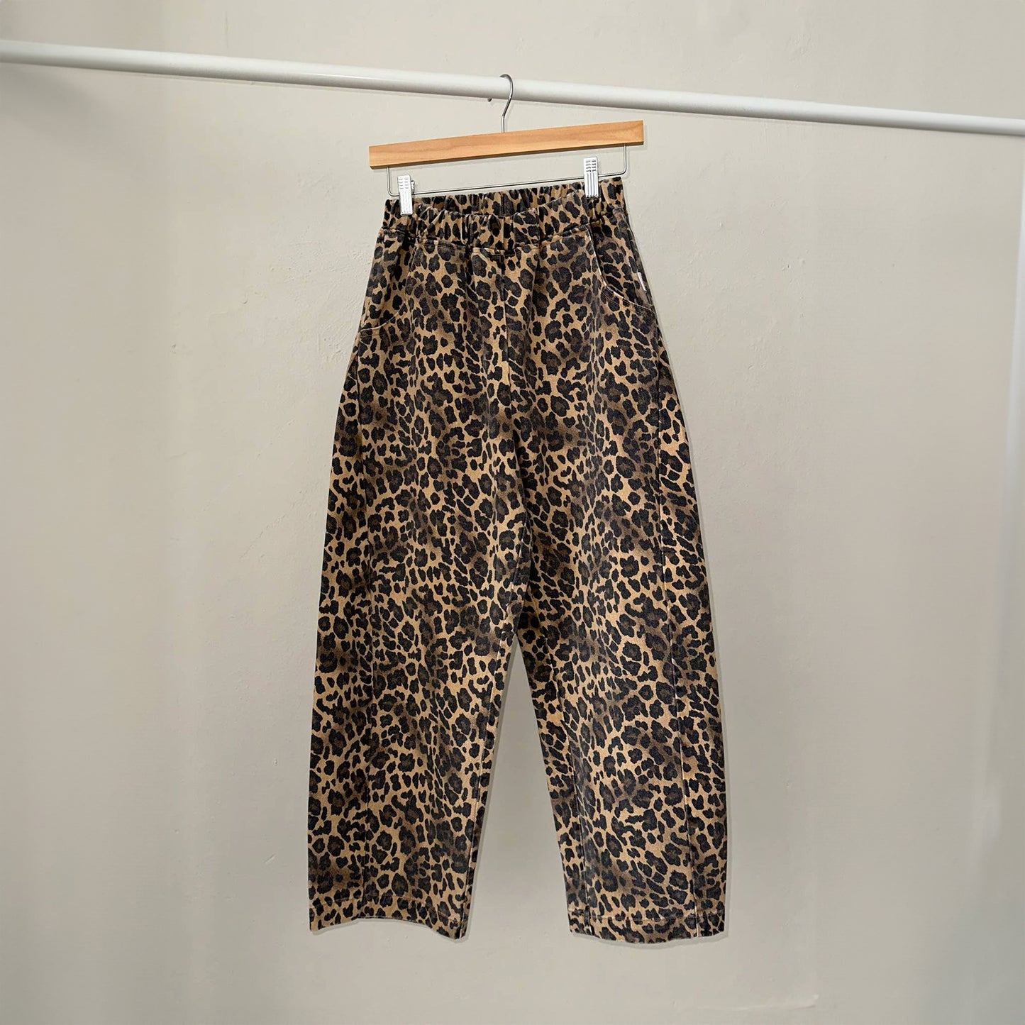 a pair of high waist denim leopard print trousers with a ballooned curved shape with a curved seam detail down both sides of the leg with an elasticated waistband