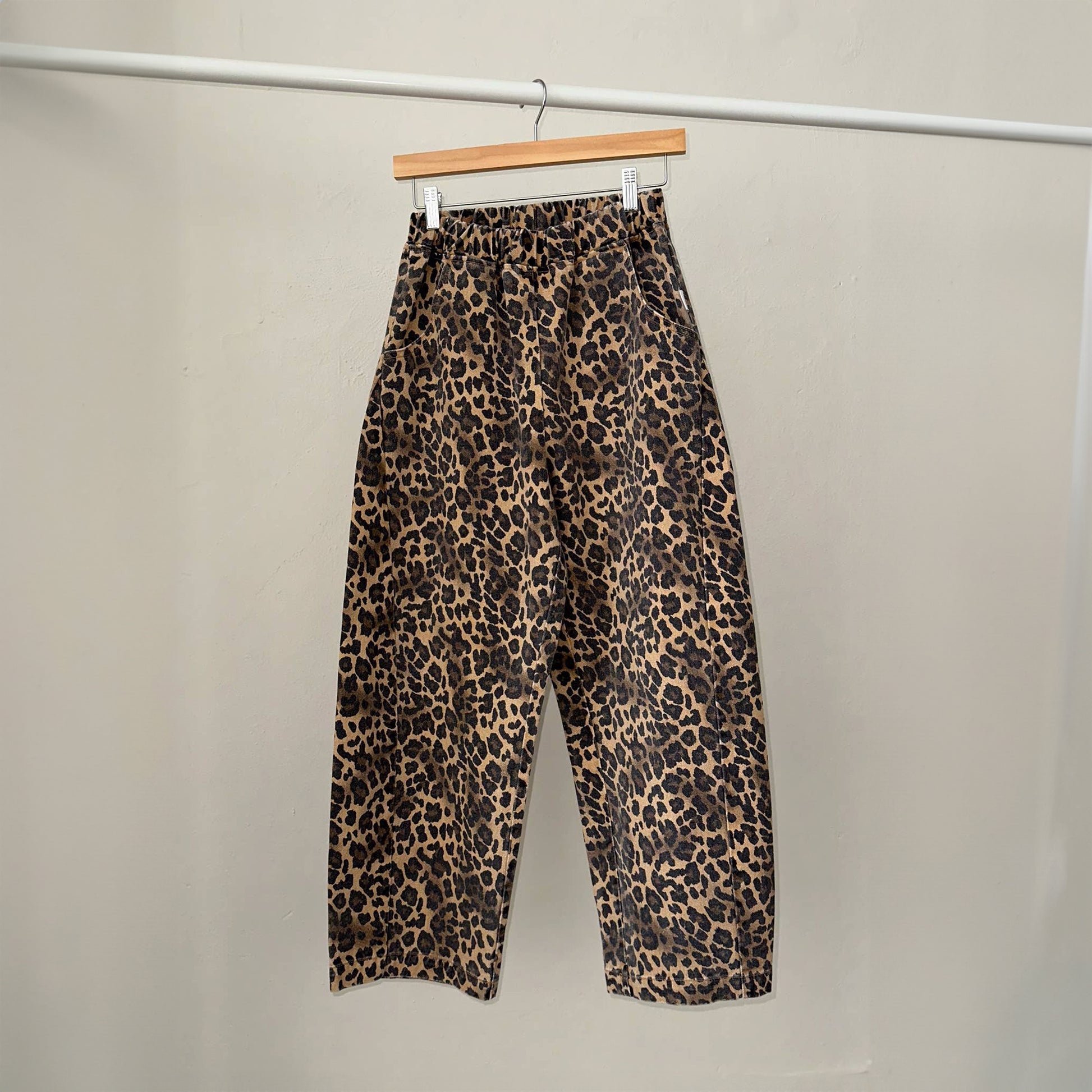 a pair of high waist denim leopard print trousers with a ballooned curved shape with a curved seam detail down both sides of the leg with an elasticated waistband