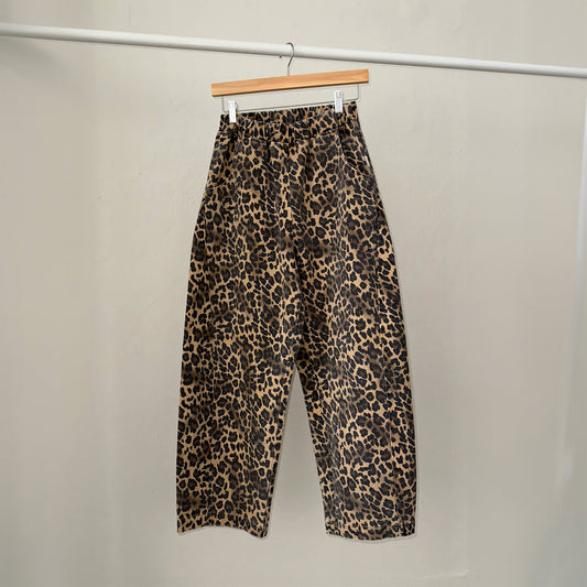 a pair of high waist denim leopard print trousers with a ballooned curved shape with a curved seam detail down both sides of the leg with an elasticated waistband